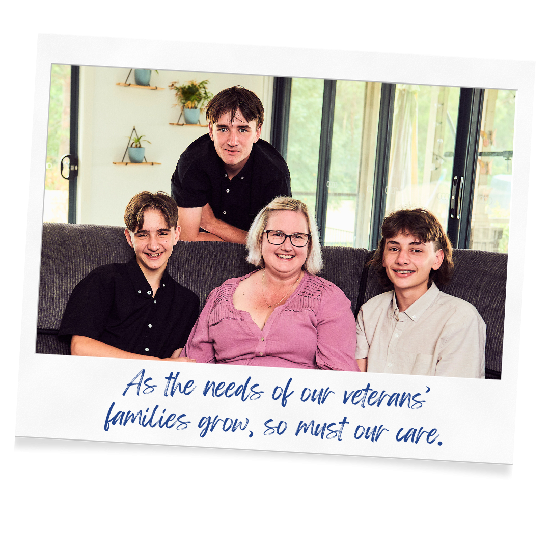 Young family of a mother and her three sons sitting together posing happily for a family photo in their home.